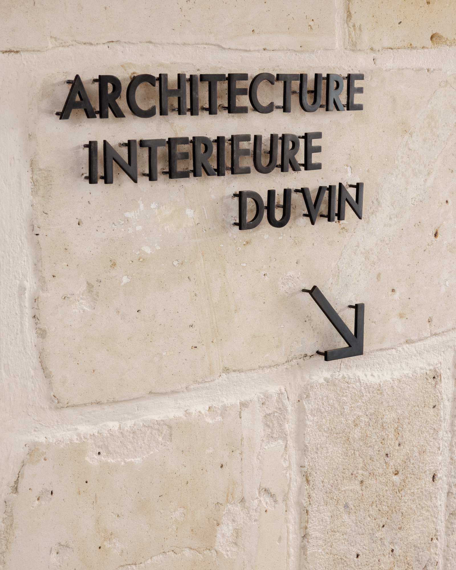 Architecture Intérieure du Vin lettering on the showroom’s stone wall