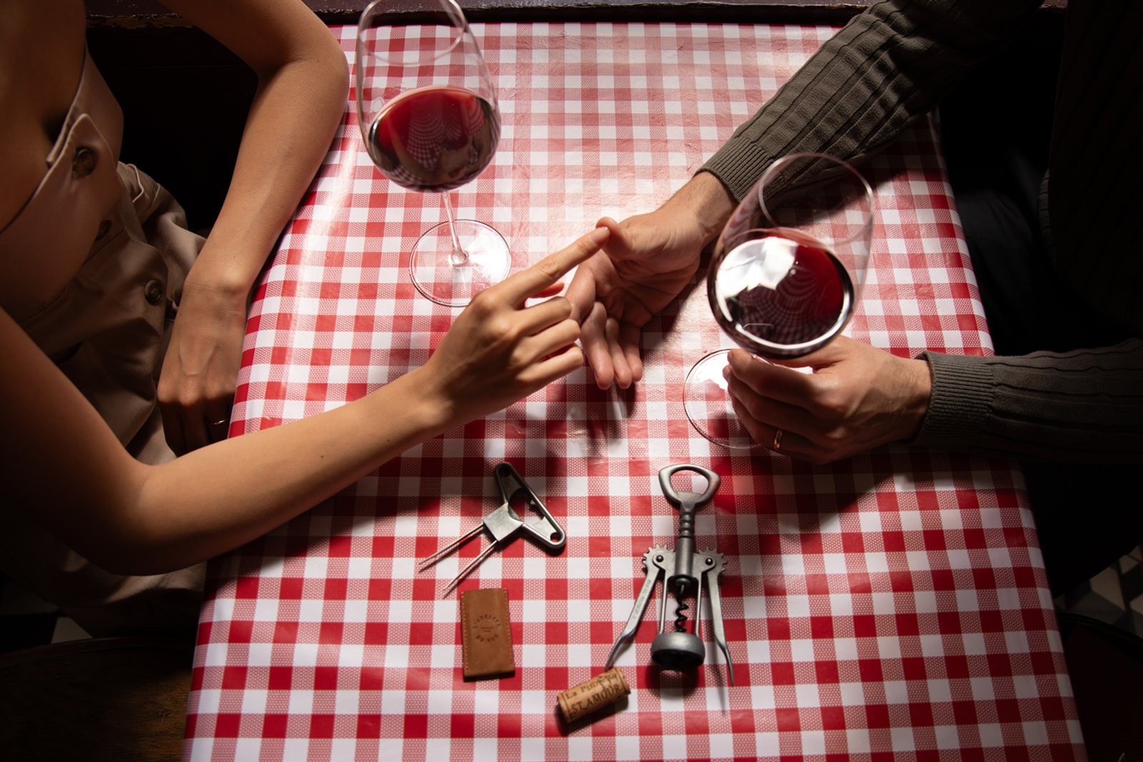 Glasses of red wine and wine accessories on a traditional Parisian bistro table.